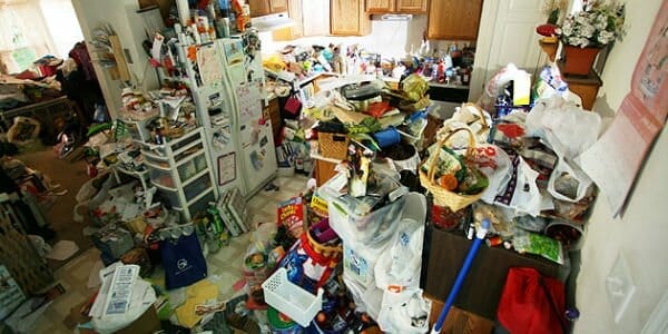 Kitchen and living room area piled with clutter.